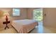 Spacious bedroom with a queen-size bed, lamp, and direct access to the backyard at 110 S Oxford Dr, Englewood, FL 34223