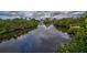 Serene waterfront view with lush vegetation and private dock at 110 S Oxford Dr, Englewood, FL 34223