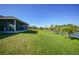 Large backyard with canal front access, lush grass and tropical plants at 9194 Impala Cir, Port Charlotte, FL 33981