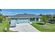 Single-story home with light teal exterior, attached garage, and landscaped lawn at 9194 Impala Cir, Port Charlotte, FL 33981