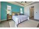 Spacious bedroom with king bed, teal walls, and ensuite access at 8250 Arlewood Cir, Port Charlotte, FL 33981