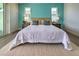 Bright bedroom with a king-size bed and teal accent wall at 8250 Arlewood Cir, Port Charlotte, FL 33981