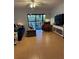 Comfortable living room with access to balcony, featuring neutral colors, tile flooring and modern ceiling fan at 1515 Forrest Nelson Blvd # A208, Port Charlotte, FL 33952