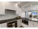 Modern kitchen with white cabinets, dark countertops, and stainless steel appliances at 5850 Gasparilla Rd # M1&3, Boca Grande, FL 33921