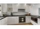 Modern kitchen with white cabinets, dark countertops, and stainless steel appliances at 5850 Gasparilla Rd # M1&3, Boca Grande, FL 33921