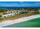 Aerial view of waterfront community with beach access, lush landscaping, and tennis courts at 5850 Gasparilla Rd # M1&3, Boca Grande, FL 33921