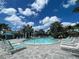 Expansive pool area with lounge chairs and palm trees at 26724 Weiskopf Dr, Englewood, FL 34223