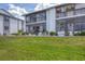 Condo exterior featuring a screened-in porch/balcony and well-maintained lawn at 6800 Placida Rd # 121, Englewood, FL 34224
