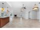 Open living room and kitchen with tile floor, fireplace and island at 600 Bramblewood Ln, Englewood, FL 34223