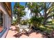 Enjoyable patio with glass-top table and chairs, surrounded by lush greenery at 600 Bramblewood Ln, Englewood, FL 34223
