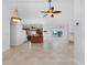 Open living room and kitchen with tile flooring, ceiling fans, and island at 600 Bramblewood Ln, Englewood, FL 34223