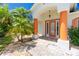 Front entryway with orange columns, a glass door and a brick walkway at 9660 Miami Cir, Port Charlotte, FL 33981