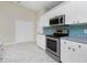 Modern kitchen with stainless steel appliances and blue backsplash at 9660 Miami Cir, Port Charlotte, FL 33981