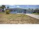 Ranch-style home with light blue exterior and a paved driveway at 22216 Midway Blvd, Port Charlotte, FL 33952
