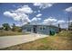 Ranch-style home with light blue exterior and a spacious front yard at 22216 Midway Blvd, Port Charlotte, FL 33952