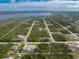 This aerial view showcases the property near a beautiful bay, with a screened pool and lots of trees at 5039 Parker St, Port Charlotte, FL 33981