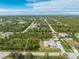 An aerial view shows a quiet neighborhood with tree coverage; and a long driveway leading up to this lovely property at 5039 Parker St, Port Charlotte, FL 33981