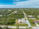 A peaceful, residential area is seen in this aerial view of the property with a long driveway and ample trees at 5039 Parker St, Port Charlotte, FL 33981