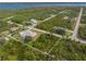 An aerial view shows a home with a pool on a large lot with plenty of trees in a quiet residential neighborhood at 5039 Parker St, Port Charlotte, FL 33981