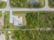 Close overhead view showcasing a single-Gathering home with a screened-in pool, adjacent vacant lot and detached garage at 5039 Parker St, Port Charlotte, FL 33981