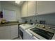 Bright laundry room with washer, dryer, and cabinets at 7486 Palm Island Dr # 2422, Placida, FL 33946
