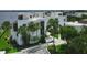 Aerial view of condo building with lush landscaping and palm trees at 2955 N Beach Rd # A-415, Englewood, FL 34223