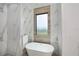 Spa-like bathroom with a freestanding soaking tub and marble tile at 10401 Sunday Dr, Port Charlotte, FL 33981