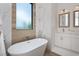 Elegant bathroom with a freestanding soaking tub, marble tile, and modern vanity at 10401 Sunday Dr, Port Charlotte, FL 33981
