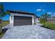 Modern home exterior featuring a gray paver driveway and dark brown garage door at 10401 Sunday Dr, Port Charlotte, FL 33981