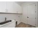 Laundry room with white cabinets, a sink, and ample storage at 10401 Sunday Dr, Port Charlotte, FL 33981