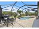 Inviting pool area with covered patio, outdoor dining, and basketball hoop at 15889 Viscount Cir, Port Charlotte, FL 33981