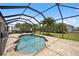 Inviting pool area with covered patio, lush landscaping, and a spacious deck at 15889 Viscount Cir, Port Charlotte, FL 33981