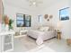 Bright bedroom with a queen bed, large windows, and stylish decor at 11042 Carnegie Ave, Englewood, FL 34224