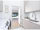 Laundry room with a door leading to backyard and modern appliances at 11042 Carnegie Ave, Englewood, FL 34224