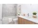 Modern bathroom with a bathtub, toilet and light wood vanity at 11042 Carnegie Ave, Englewood, FL 34224