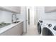 Laundry room with modern washer, dryer, and a quartz countertop at 11042 Carnegie Ave, Englewood, FL 34224