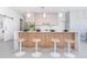 Modern kitchen island with wood accents and four barstools at 11042 Carnegie Ave, Englewood, FL 34224