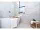 Relaxing bathroom with a soaking tub, marble tile, and window at 11042 Carnegie Ave, Englewood, FL 34224