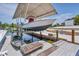 Boat lift with covered storage and a kayak on the dock at 245 Spaniards Rd, Placida, FL 33946