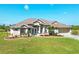One-story home with a tan exterior, tile roof, and landscaping at 14091 Peekskill Ave, Port Charlotte, FL 33981