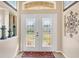 Bright entryway with double leaded glass doors and decorative wall art at 14091 Peekskill Ave, Port Charlotte, FL 33981