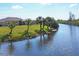 Home on a canal with lush landscaping and palm trees at 14091 Peekskill Ave, Port Charlotte, FL 33981