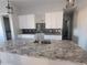 Modern kitchen with white cabinets, granite countertops, and dark tile backsplash at 2170 Doolittle Ln, Port Charlotte, FL 33953