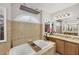 Soaking tub in a bathroom with beautiful decorative tile, a marble countertop, and natural light at 254 Orlando Blvd, Port Charlotte, FL 33954