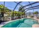 Sparkling pool surrounded by a screened enclosure and tropical landscaping at 254 Orlando Blvd, Port Charlotte, FL 33954