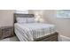 Cozy bedroom featuring a stylish wooden bed frame, striped bedding, and matching nightstand with a lamp at 285 Mark Twain Ln, Rotonda West, FL 33947