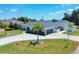 An aerial view showcasing a single-Gathering house with a spacious front yard and a paved driveway at 254 Orlando Blvd, Port Charlotte, FL 33954