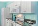 White kitchen cabinets and black countertops at 285 Mark Twain Ln, Rotonda West, FL 33947