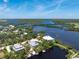 Impressive aerial view overlooking the home, dock, and tranquil waterfront location at 13074 Via Flavia, Placida, FL 33946