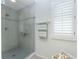 Modern bathroom featuring a glass-enclosed shower with tile surround and built-in shelving at 13074 Via Flavia, Placida, FL 33946